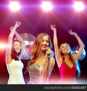 new year, celebration, friends, bachelorette party, birthday concept - three women in evening dresses dancing and singing karaoke