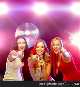 new year, celebration, friends, bachelorette party, birthday concept - three women in evening dresses dancing and singing karaoke