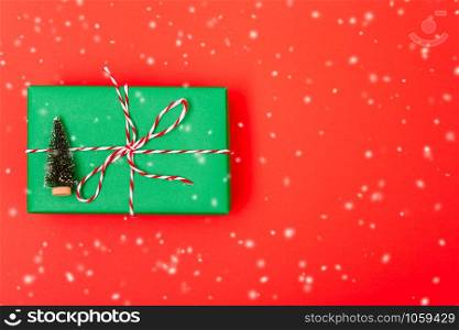 New Year, Christmas Xmas holiday composition, Top view gift green box, clews of rope and green fir tree branch on red background with copy space
