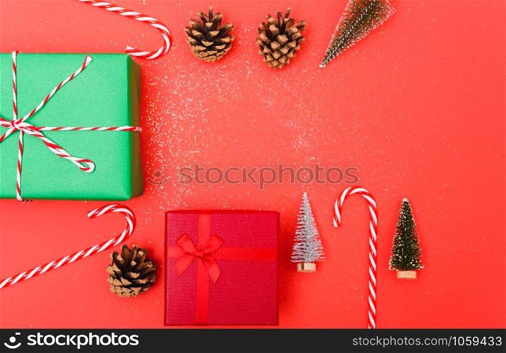 New Year, Christmas Xmas holiday composition, Top view green and red gift box, clews of rope, green fir tree branch on red background with copy space