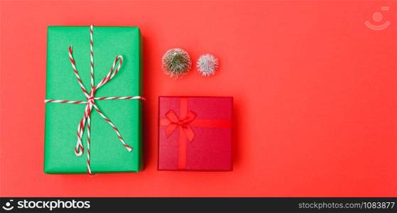 New Year, Christmas Xmas holiday composition, Top view green and red gift box and green fir tree branch on red background with copy space