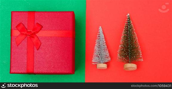 New Year, Christmas Xmas holiday composition, Top view green fir tree branch and red gift box on red and green background with copy space
