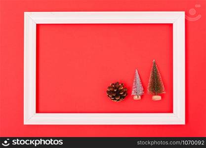 New Year, Christmas Xmas holiday composition, Top view green fir tree branch in frame on red background with copy space