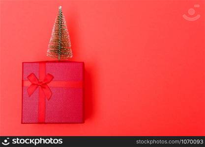 New Year, Christmas Xmas holiday composition, Top view red gift box with green fir tree branch over box on red background