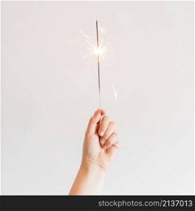 new year composition with hand holding sparkler