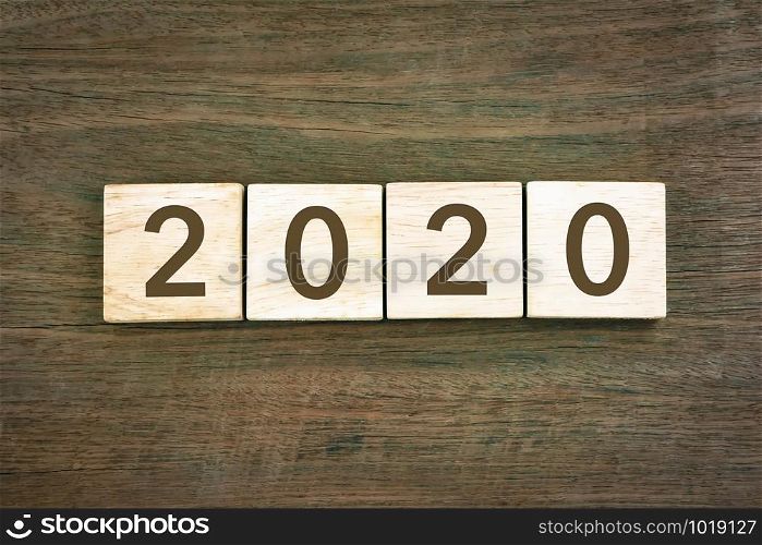 New year Concept 2020 number and typography text on wooden blocks with wood texture background. Top view from above, vintage style for new year resolution and business plan.