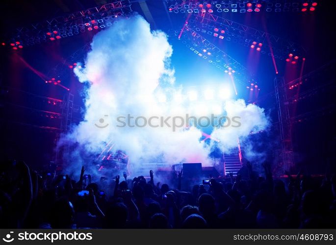New year eve celebration, rock concert show, happy people silhouettes, raise up hands, disco party with large group of dancing man, blue stage lights, active lifestyle, music entertainment, nightclub
