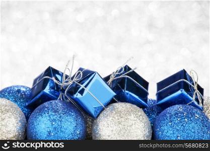 New Year gift and balls on shiny silver bokeh background
