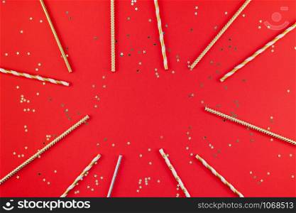 New Year or Christmas pattern flat lay top view Xmas holiday 2019 celebration drinking cocktail party straws red paper golden sparkles background. Template for greeting card your text design