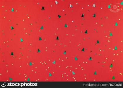 New Year or Christmas pattern flat lay top view Xmas holiday 2019 celebration red paper golden and green sparkles confetti background. Template for greeting card your text design