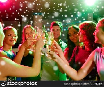 new year party, holidays, celebration, nightlife and people concept - smiling friends with glasses of non-alcoholic champagne in club and snow effect