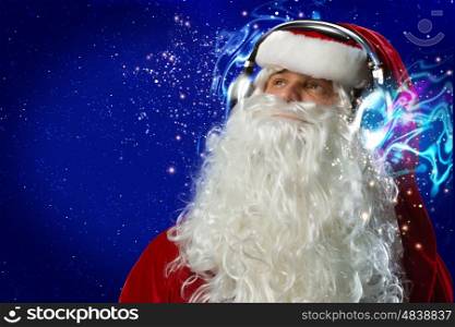 New Year party. Santa Claus wearing headphones and enjoying music