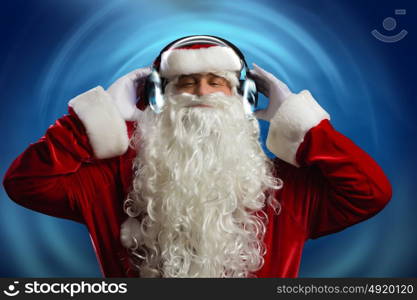 New Year party. Santa Claus wearing headphones and enjoying music