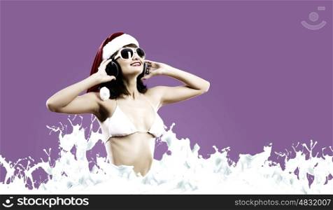 New Year Party. Young Santa girl in white bikini and headphones