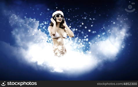 New Year Party. Young Santa girl in white bikini and headphones