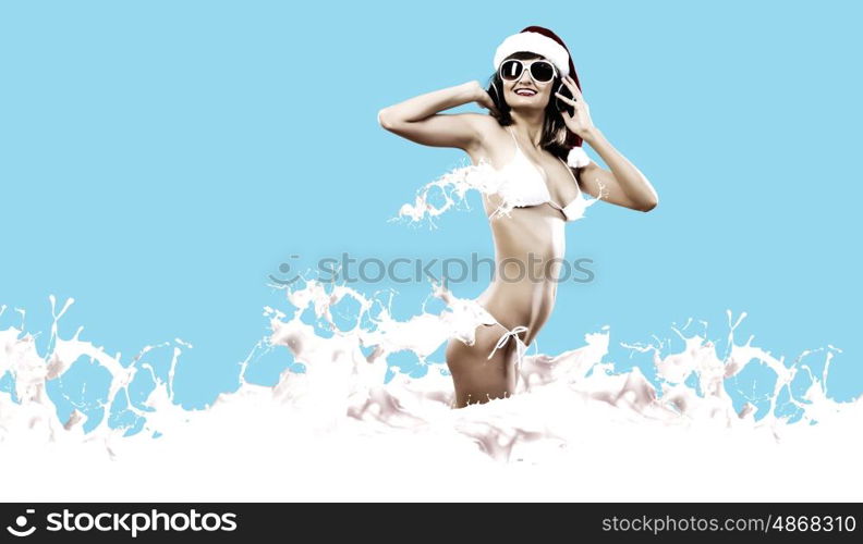 New Year Party. Young Santa girl in white bikini and headphones