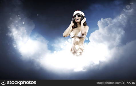 New Year Party. Young Santa girl in white bikini and headphones