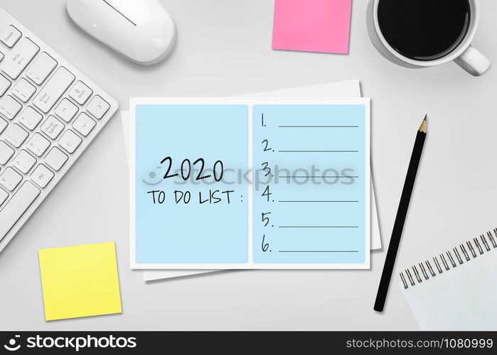 New Year Resolution Goal List 2020 - Business office desk with notebook written in handwriting about plan listing of new year goals and resolutions setting. Change and determination concept.