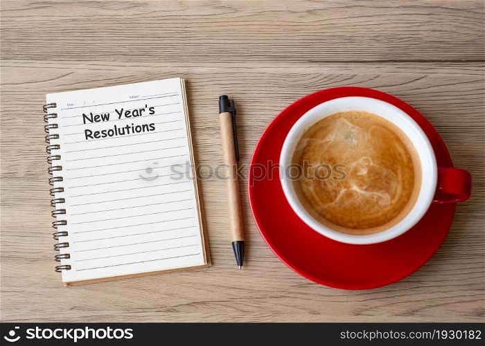 New Year Resolution with notebook, black coffee cup and pen on wood table. Xmas, Happy New Year, Goals, To do list, Strategy and Plan concept