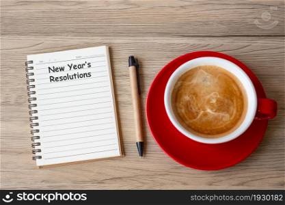 New Year Resolution with notebook, black coffee cup and pen on wood table. Xmas, Happy New Year, Goals, To do list, Strategy and Plan concept