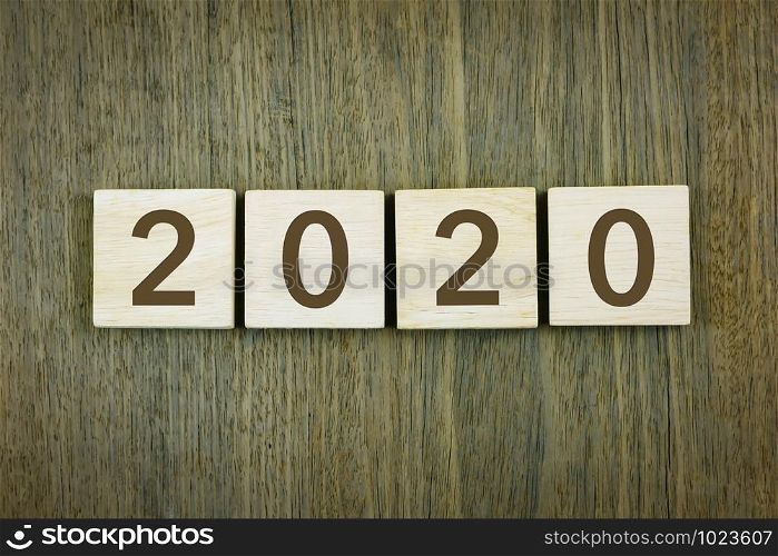 New year&rsquo;s 2020 for goals setting, business planning and resolutions concepts. Typography numbers on wooden blocks over wood texture background, vintage style.