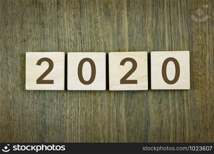 New year&rsquo;s 2020 for goals setting, business planning and resolutions concepts. Typography numbers on wooden blocks over wood texture background, vintage style.