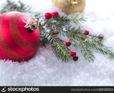 New Year&rsquo;s background. Christmas tree branch with red berries and red Christmas tree ball