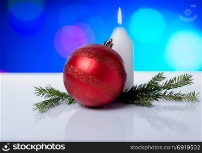New Year&rsquo;s background. White candle, Christmas ball and branches on a background with a bok