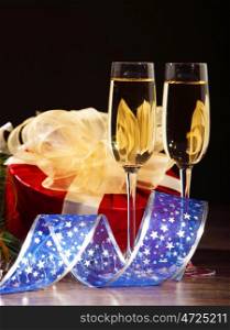 New Year's still life with glasses of champagne. Decorations and ribbons on a bright color background