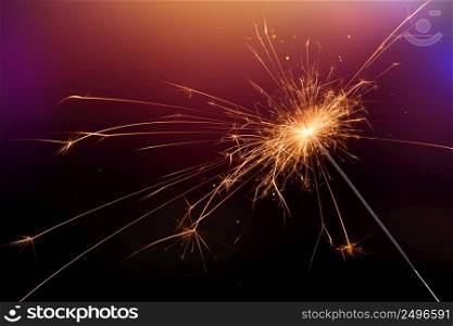 New year sparkler glittering candle magic festive light on dark background. Christmas party sparkler or Bengal fire. 