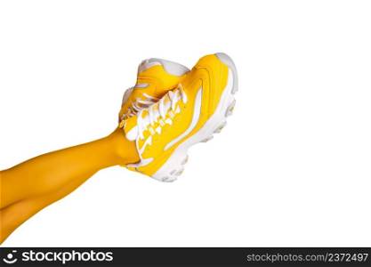 New Yellow female sneakers on long slender woman legs in yellow tights isolated on white background. Banner with copy space.. New Yellow female sneakers on long slender woman legs in yellow tights isolated on white background. Banner with copy space