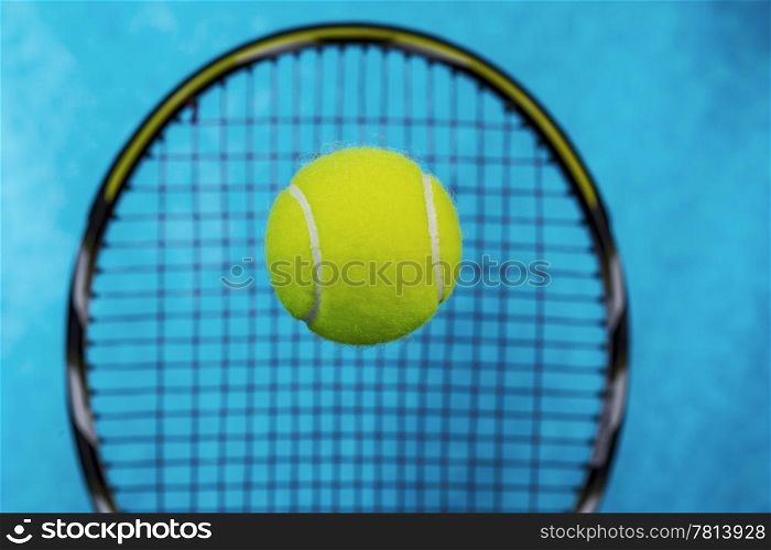 New yellow tennis ball with racket and light blue sky like background