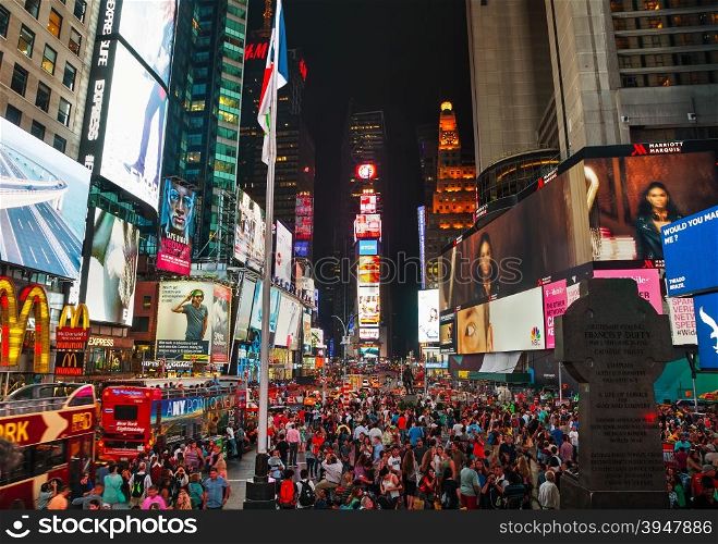 NEW YORK CITY - SEPTEMBER 05: Times square with people in the night on September 5, 2015 in New York City. It&rsquo;s major commercial intersection and neighborhood in Midtown Manhattan at the junction of Broadway and 7th Avenue.
