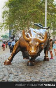 "NEW YORK CITY - September 3: Charging Bull sculpture with people on September 3, 2015 in New York City. The sculpture is both a popular tourist destination, as well as "one of the most iconic images of New York"."
