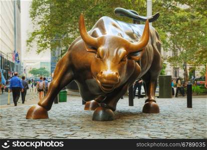 "NEW YORK CITY - September 3: Charging Bull sculpture with people on September 3, 2015 in New York City. The sculpture is both a popular tourist destination, as well as "one of the most iconic images of New York"."