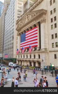 NEW YORK CITY - September 3: New York Stock Exchange building with people on September 3, 2015 in New York. The NYSE trading floor is located at 11 Wall Street and is composed of 4 rooms used for facilitation of trading.