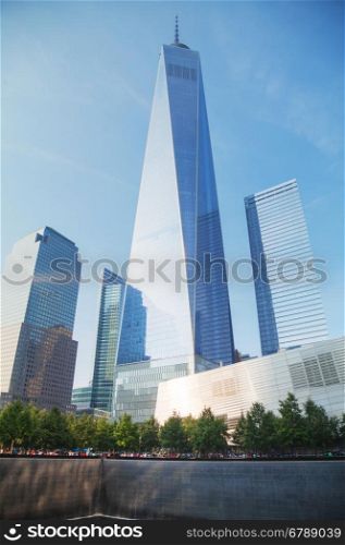 NEW YORK CITY - SEPTEMBER 3: One World Trade Center and 9/11 Memorial with people on September 3, 2015 in New York City.