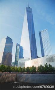 NEW YORK CITY - SEPTEMBER 3: One World Trade Center and 9/11 Memorial with people on September 3, 2015 in New York City.