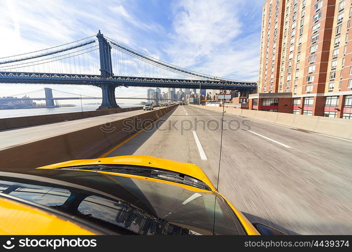 New York City yellow taxi cab driving under Manhattan Bridge