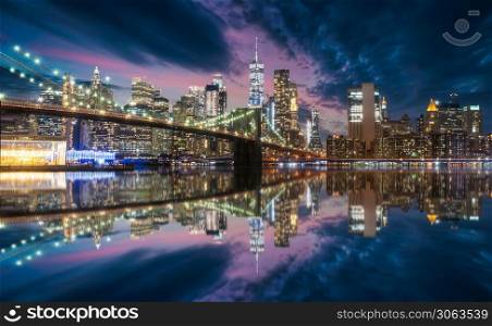 New york skyline from Brooklyn bridge in blue hour with reflection on Hudson river