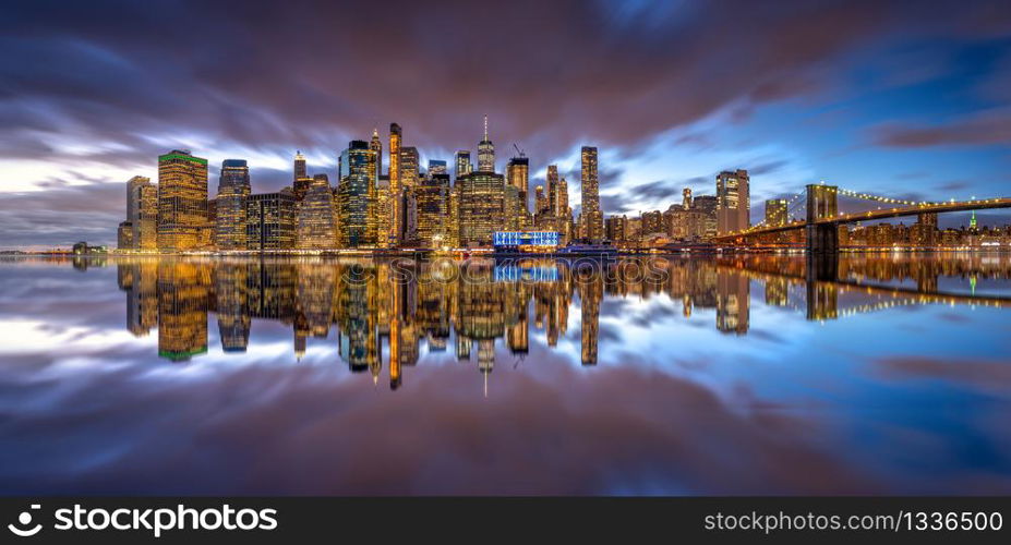 New york skyline reflection on the Hudson river at Brooklyn bridge at sunset