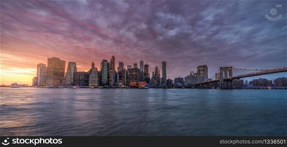 New york skyline reflection on the Hudson river at Brooklyn bridge at sunset