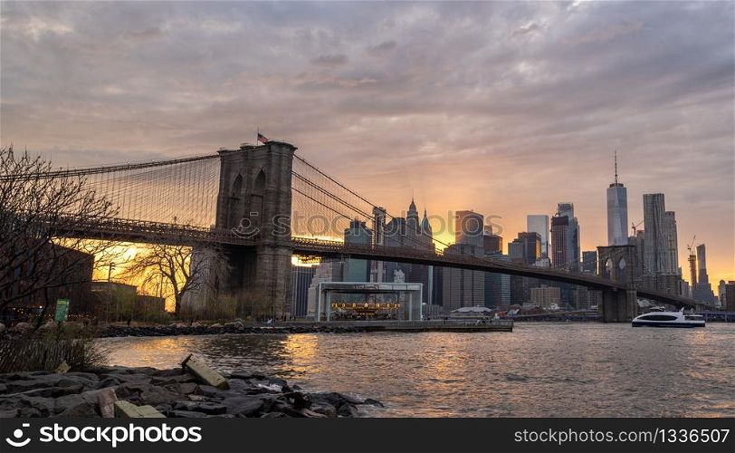 New york skyline reflection on the Hudson river at Brooklyn bridge at sunset