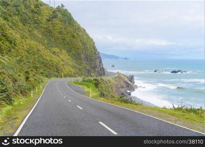 New Zealand Coastal Highway: A scenic road winds along the western shore of New Zealand's South Island.