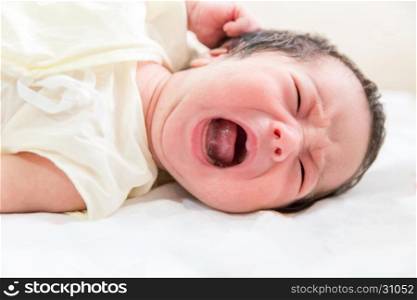 newborn baby crying in her bed