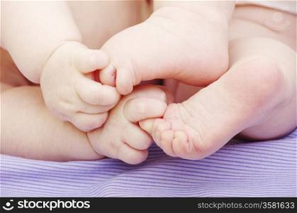 newborn baby feet and hands isolated on blue