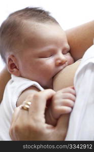 Newborn baby gets breastfeeding while his mother holds his hand