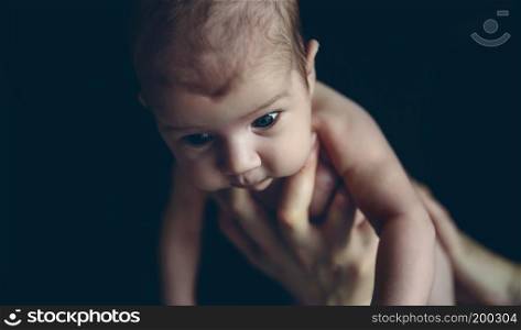 Newborn baby girl held by her mother with one hand. Newborn baby girl held by one hand