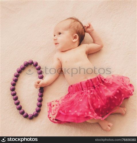 newborn baby girl in skirt with beads. newborn baby girl in skirt