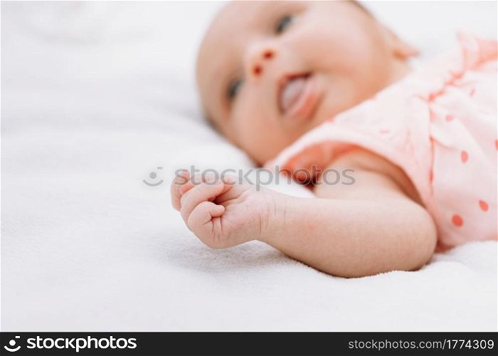 Newborn baby girl on grass in the park outdoors, lies on a white blanket looking around. selective focus. Newborn baby girl on grass in the park outdoors, lies on a white blanket looking around. selective focus.